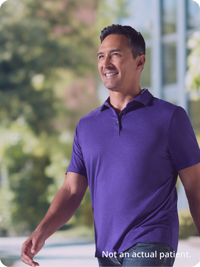 Person in a purple shirt walking and smiling
